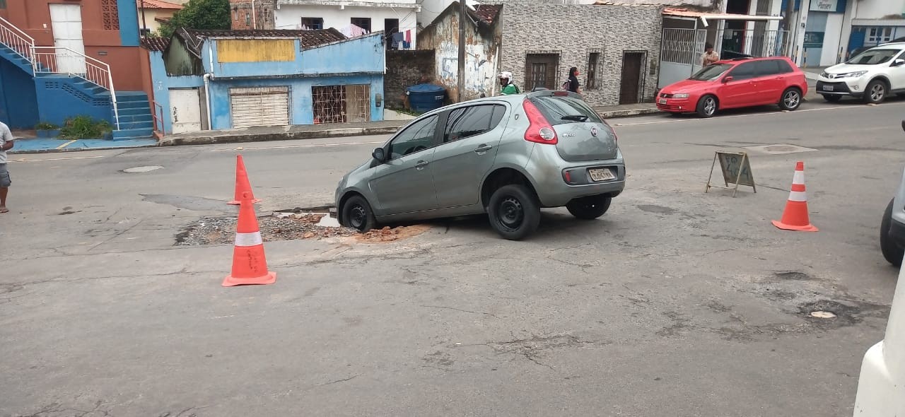 Carro cai e fica preso em buraco formado após vazamento de tubulação em Pernambués